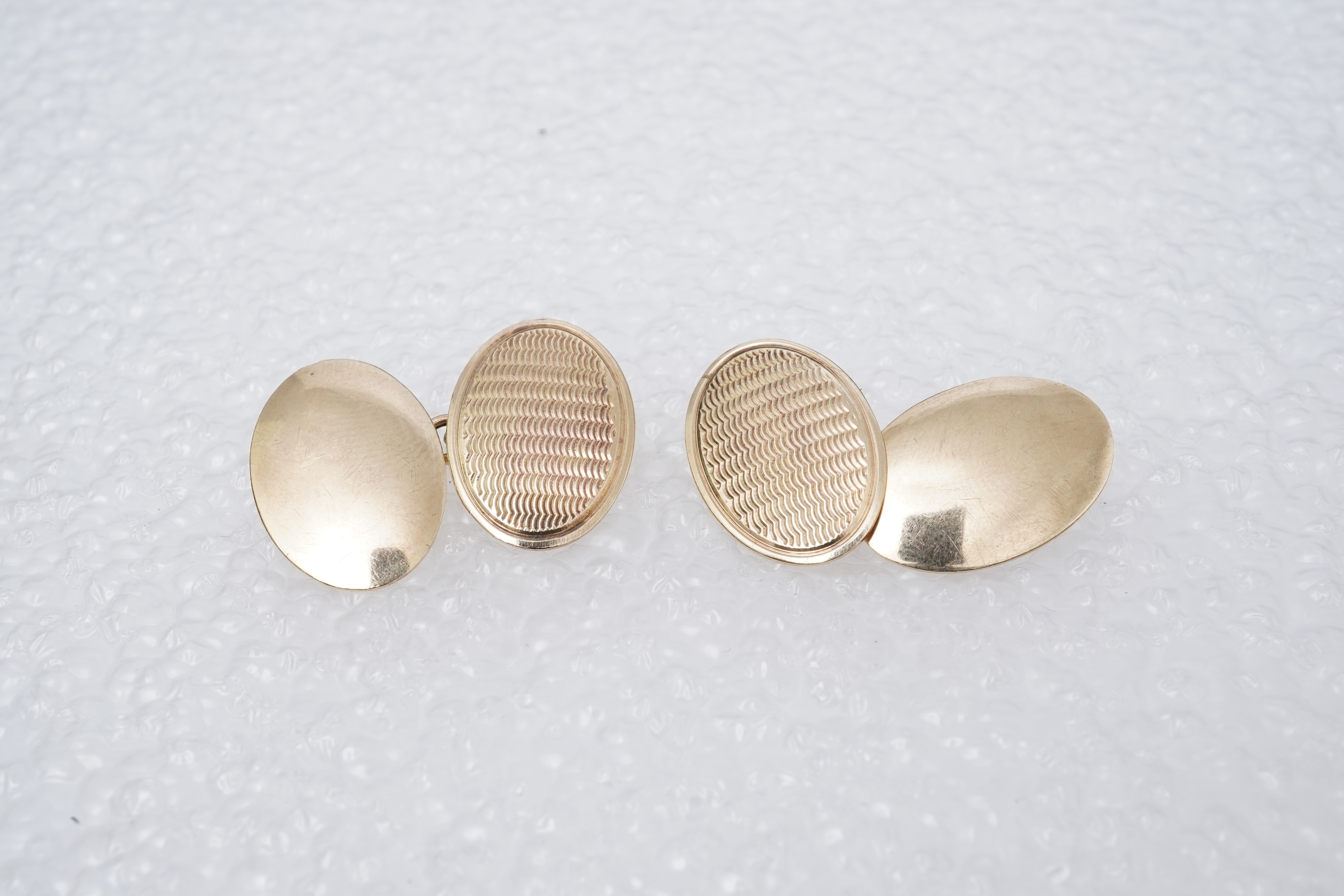 A yellow metal wedding band, a pair of 9ct gold plain oval cufflinks and a 9ct bar brooch, gross weight 11 grams.